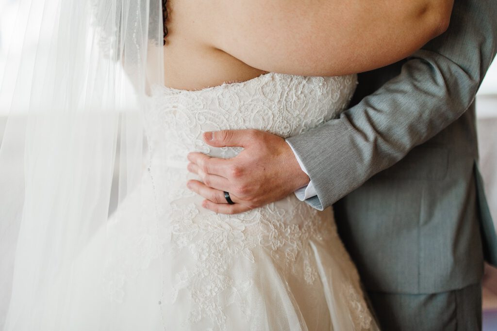suknie ślubne dla puszystych - pan młody obejmujący pannę młodą plus size