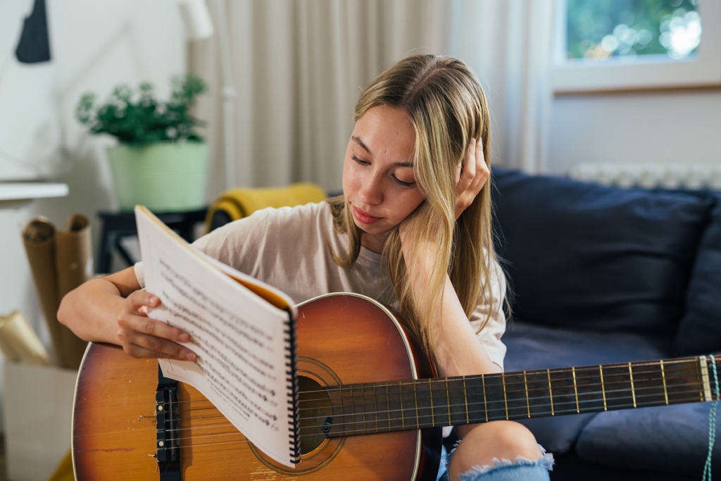 Śpiewnik weselny trzymany w ręku przez gitarzystkę