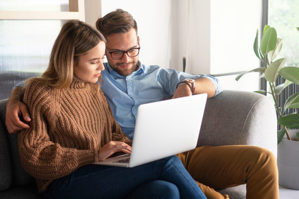 zaproszenia ślubne online - mężczyzna pokazuje coś kobiecie na laptopie